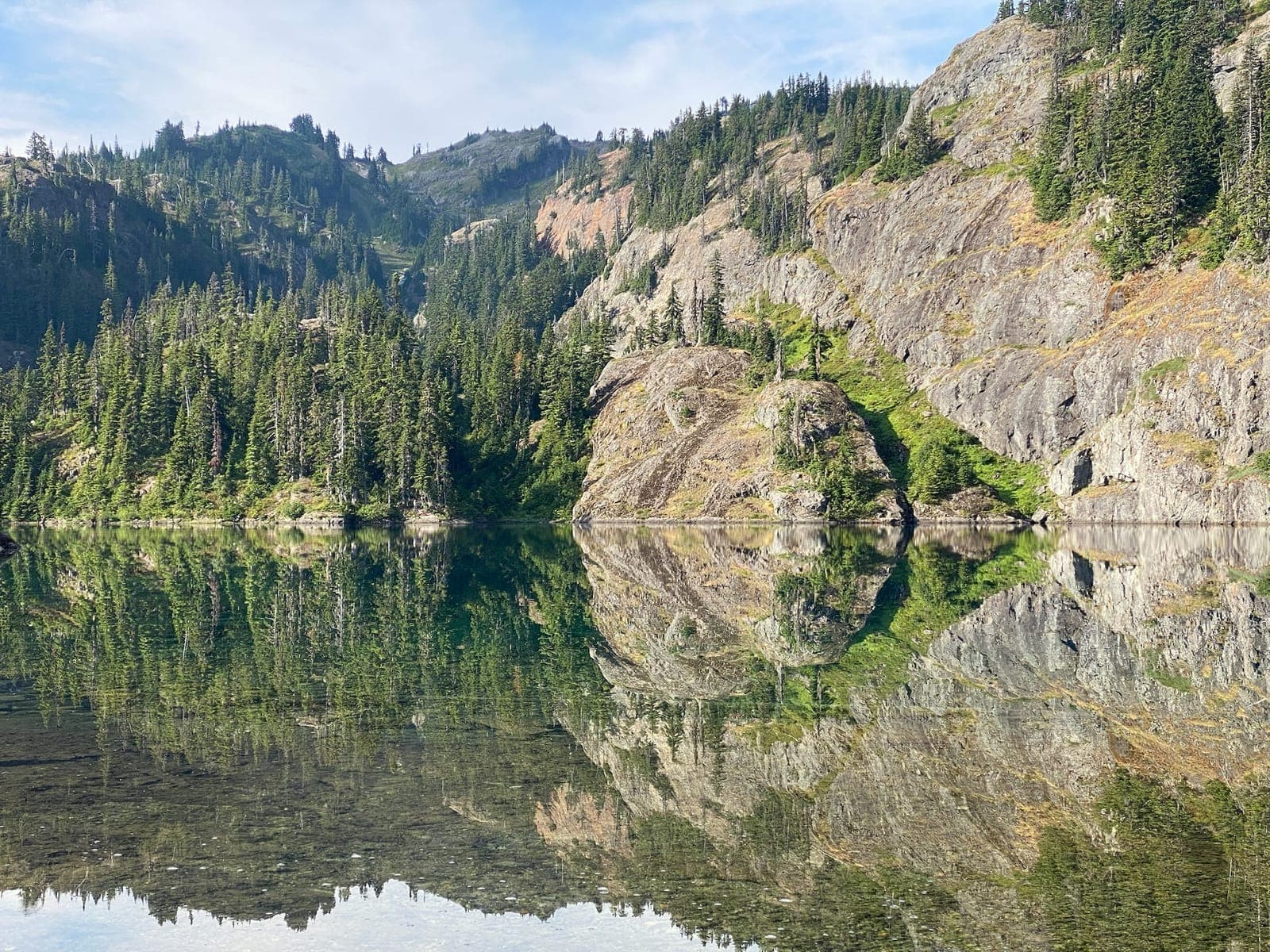 Trees reflecting on the calm water at Rachel Lake